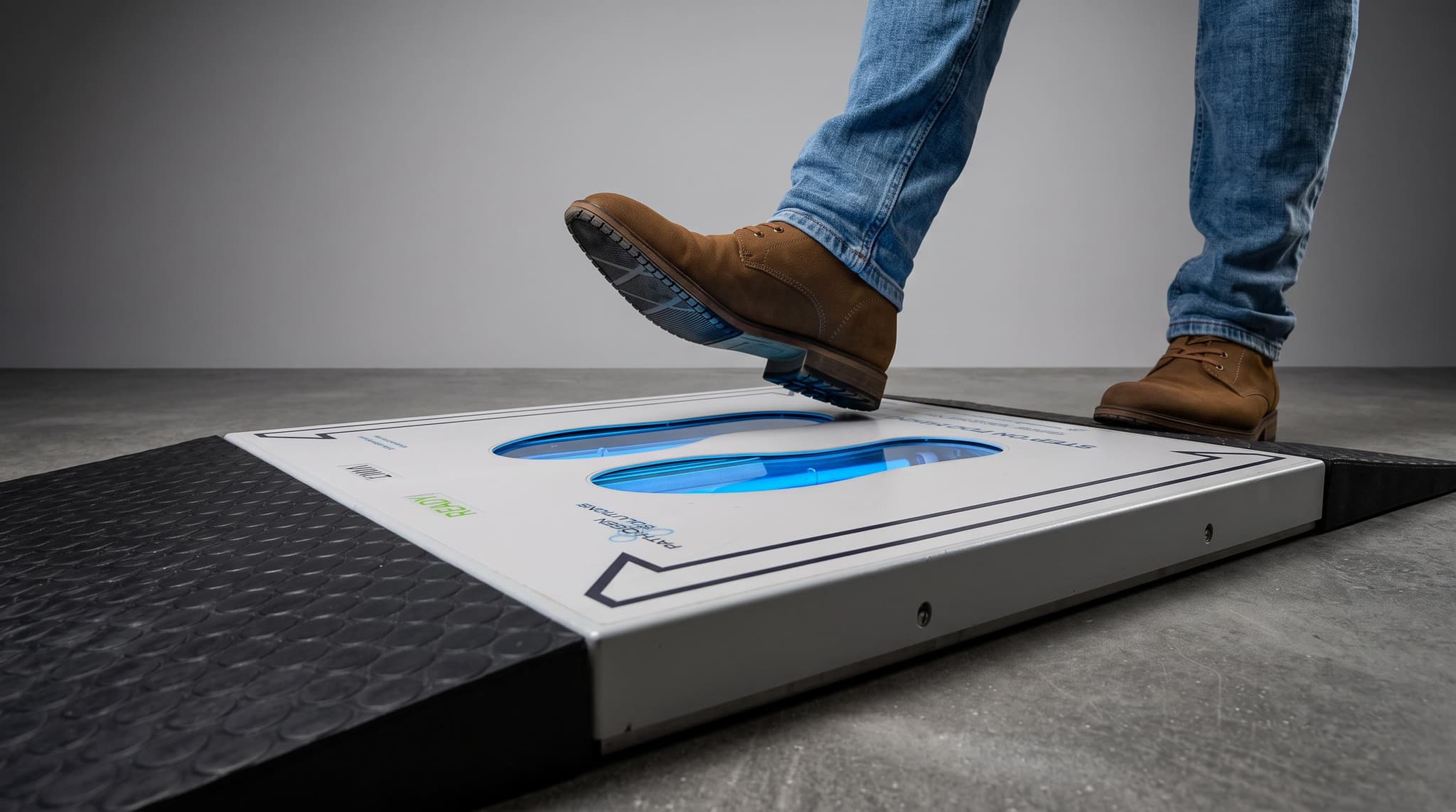 User standing with both feet positioned on the UVZone Shoe Sanitizing Station during an activated shoe-sole treatment cycle.