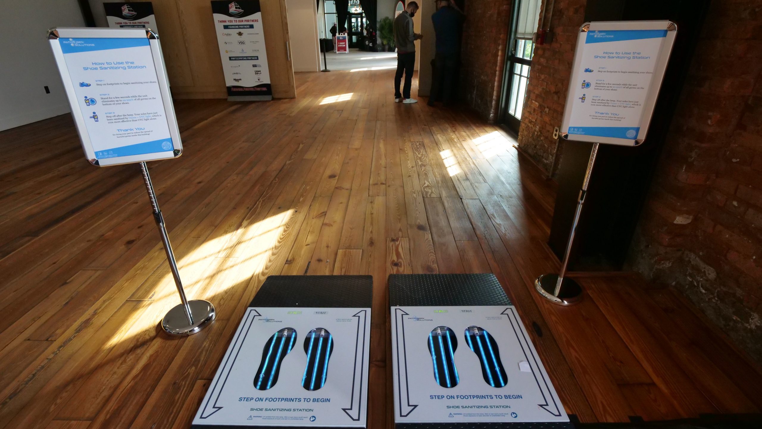 Two PathO₃Gen Solutions' UVZone® Shoe Sanitizers placed side-by-side at the entrance of an event, ensuring attendees' footwear remains clean and germ-free.